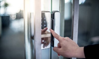 Businessman hand pressing down password number on electronic access control machine to open the office door. Security system concept